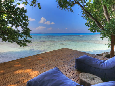 Bean bags on deck above water with views to the sea.PNG